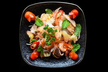 Salad made of shrimps and grapefruit isolated on black background top view