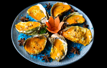 Fototapeta na wymiar oysters baked with cheese on plate with blue salt isolated on black side view