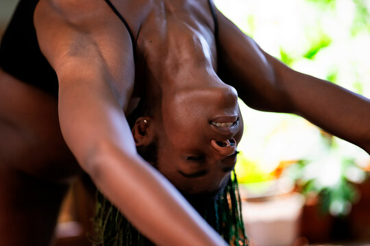 Black woman with dreadlocks spending time practicing yoga meditating and stretching