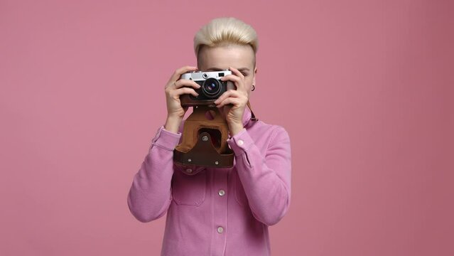 Smiling woman amazed while looking at photos. Portrait of professional, female photographer taking pictures in the studio. High quality 4k footage