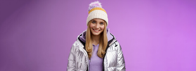 Cute young blond european woman wearing warm cozy jacket hat ski resort vacation having fun smiling...