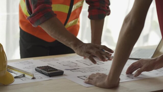 Two caucasian architects working on a project at the designer's office looking at building plans Engineer or Architect or Technician The contractor is looking at the construction drawings of the proje