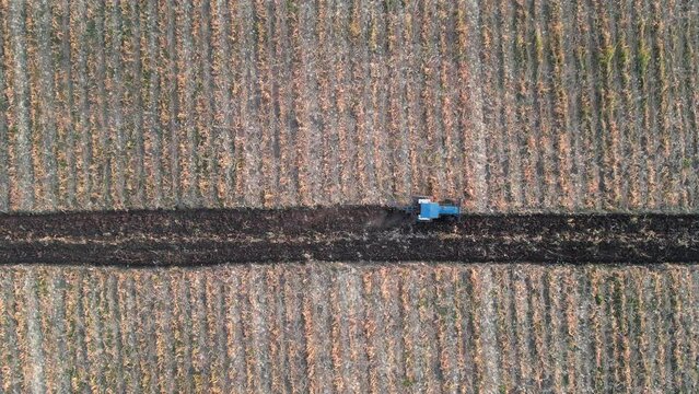 A tractor is laboring a field in Thailand