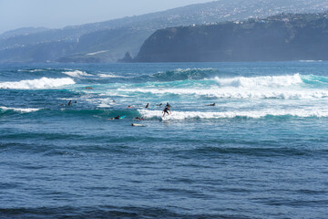 A group of surfers on the waves. Tenerife. Canary Islands. Spain