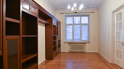 An empty room with a large window, rent sale and furniture made natural wood.