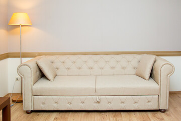 Light leather sofa in real apartment.