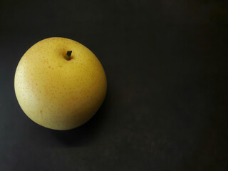 Photo of a yellow pear on a black background
