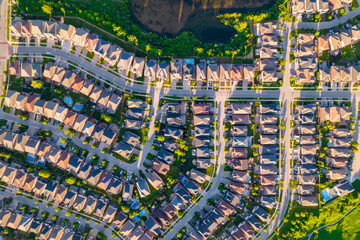 Aerial view of middle class residential houses at summer evening. American neighbourhood suburb. Residential houses and homes build in strong pattern to each other. Real estate. - 552923911