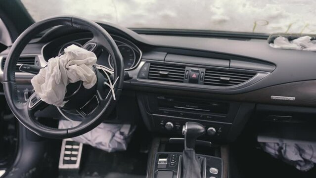Car interior after an accident with airbags deployed. View from the inside of the cabin.