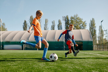 Portrait of school boys training soccer on football field