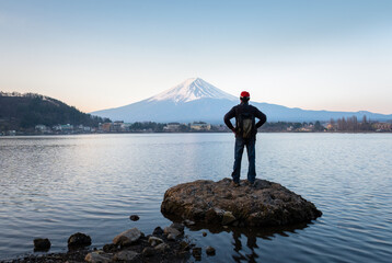Fototapeta na wymiar Man enjoying the view of sunrise over Mt Fuji, northern shore of Lake Kawaguchiko, Japan.