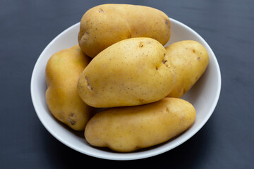 Raw potatoes isolated on dark background
