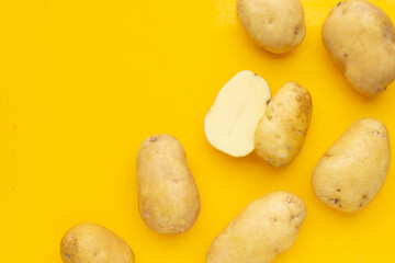 Obraz premium Raw potatoes isolated on yellow background