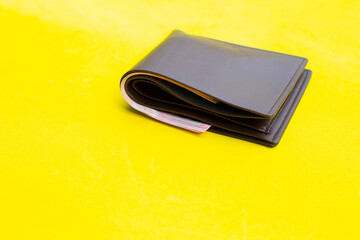 Brown wallet on yellow background