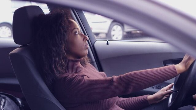 young beautiful woman in the car waits for someone impatient