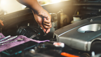A mechanic is fixing the engine of a car in a car service.