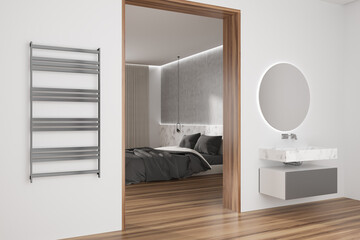 Light bedroom interior with bed and sink with towel rail on wall