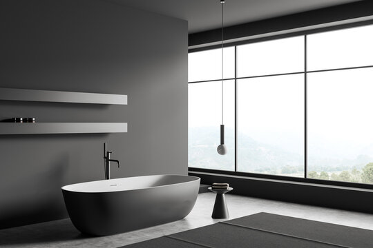 Grey bathroom interior with bathtub and accessories, panoramic window