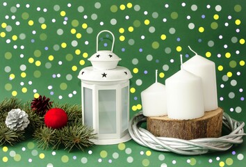 A magical white lantern on a festive New Year's background, white candles and a spruce branch decorated with Christmas toys.  Glowing lights.  Home decor concept for Christmas and New Year holiday.  
