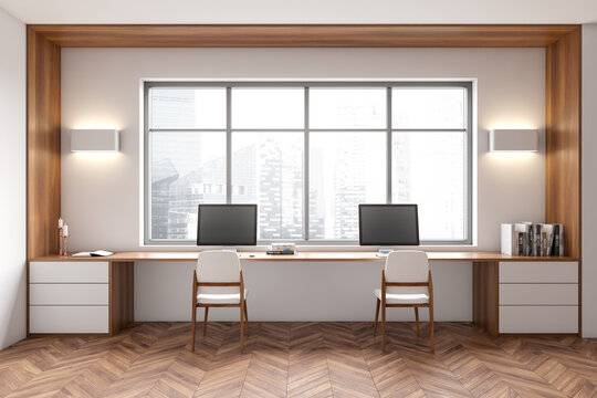 Front view on bright office room interior with two computers