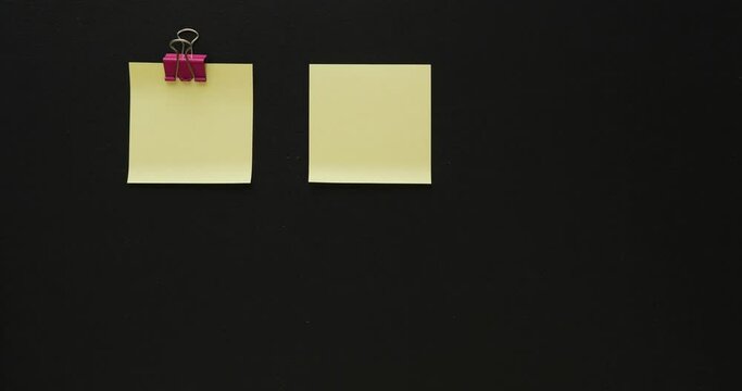 Collection of empty pinned yellow memo papers on a black background. Looped 4K stop motion animation