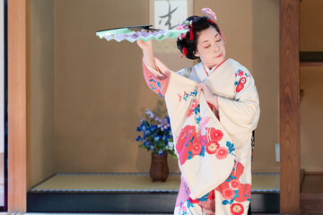 着物姿で扇子を持って日本舞踊を踊る年配の日本人女性