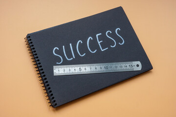 Notepad with the inscription success and a ruler for measuring it.