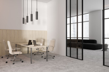 Light business interior with workplace and laptop, relaxing zone and window