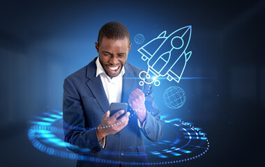 African businessman with phone and raised fist, rocket hologram hud taking off