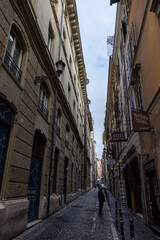 Man walking on a narrow cobblestone street, Rome, Italy