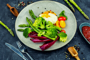 Healthy salad of asparagus, lettuce and poached eggs.