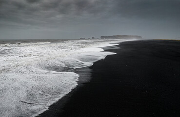 Fototapeta premium Dramatic coastal landscape from drone aerial view of waves crashing on a reynisfjara black beach Reynisfjara, Vik and Myrdal in Golden Circle in Iceland