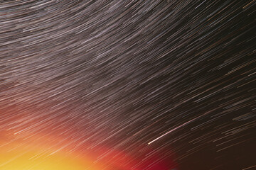 Meteors Trace On Night Dark Blue Sky Background. Spin Of Unusual Amazing Stars Effect In Sky. Abstract Bewitching Illusion Of Star Trails. Saturated Bright Yellow, Orange Colors.