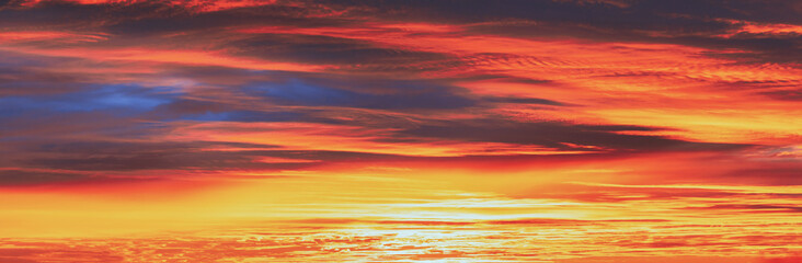 Obraz premium Panoramic View Sky Sunset Sunrise Background. Abstract Saturated Orange-yellow Colors Of Clouds. Unusual Sky Background. Rich Orange Colors. Toned Pink-yellow Clouds. Cloudy Sky. Sunny Cloudscape.
