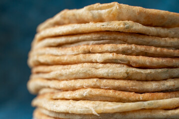 Flatbread lavash, chapati, naan, heap of tortilla on a blue background Homemade flatbread stacked.