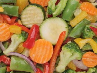 Vegetables mix carrot, green beans, broccoli, sweet paprika, onion in ice glaze close up. Healthy...