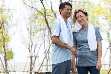 happy couple asian elder take care and support after jogging running with smile in park