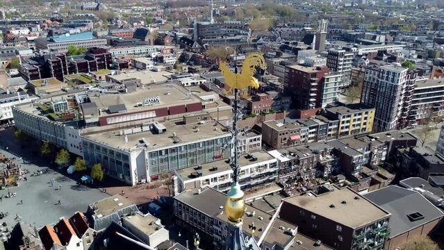Aerial close up bird view of Stevenschurch top of bell tower showing the golden cock ornament and the bells behind the windows gothic architecture church built in the 13th to 16th century 4k