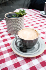 A cup of hot caffe latte on an outdoor cafe table