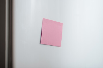 Blank self-adhesive sticker mockup on refrigerator door, selective focus on reminder sheet