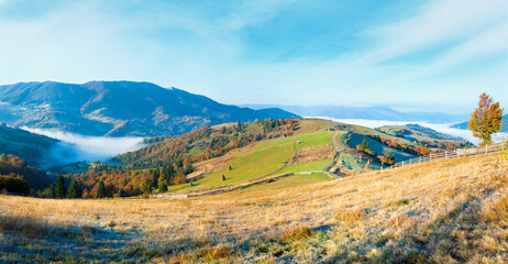 Obraz premium Autumn misty morning plateau with stack of hay and country dirty road (Mighgirya village outskirts, Carpathian Mountains, Ukraine).