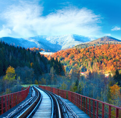 Railway on bridge and first autumn snow on far mountains