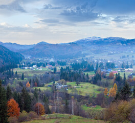 Fototapeta premium Autumn misty mountain landscape (dull day) with village in valley (Carpathian, Ukraine)