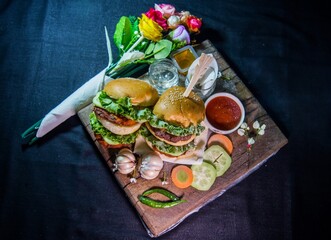 A burger is a flat round mass of minced meat or vegetables, which is fried and often eaten in a bread roll