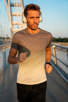Fitness sport people lifestyle concept. Portrait of young man running to stay healthy outdoors.