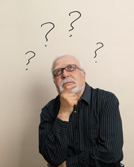 Elderly man in glasses sits thoughtfully on a light background, question marks above his head, the concept of the eternal question, vertical format