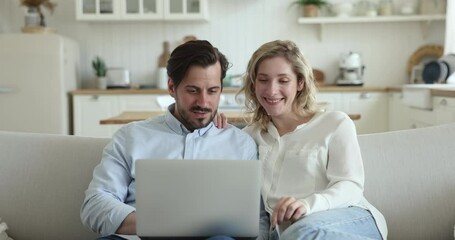 Beautiful 30s couple screaming with joy celebrate on-line lottery, betting, jackpot victory feel happy sit on sofa with laptop. Great news, get huge discounts or commercial offer. Promotion, win, luck - Powered by Adobe