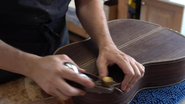 Spanish guitar maker, or luthier, working on a flamenco guitar.