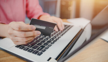 Fototapeta premium Online payment, Close-up of woman hands hold credit card and typing laptop for online shopping. Businessman, entrepreneur working, e-commerce, internet banking, spend money, working from home concept.