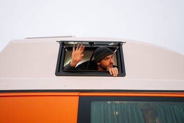 Man leaning out of the van window. © karrastock